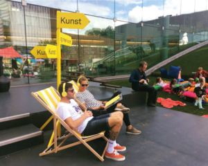 Bezoekers die kunst kijken in de KOR-strandstoelen